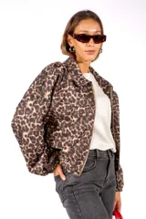 Campera de corte holgado con estampado animal print de leopardo, cuello camisero, cierre frontal y mangas largas con puños elásticos.