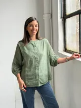Camisa de lino verde melange, con cuello mao, mangas 3/4 y cierre frontal de botones.