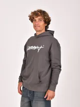 Buzo canguro negro con capucha, manga larga y bolsillo canguro frontal. Presenta un estampado blanco en el pecho con un logo circular y el texto "VISIONS OF A PARADOX MCMXXXVII".