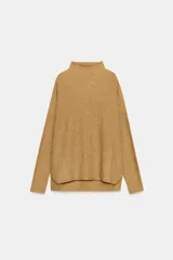Jersey de punto con textura, cuello subido y manga larga. Presenta un diseño holgado con bajo asimétrico y aberturas laterales.