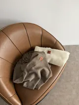 Ruana negra de tejido liviano con terminación de flecos en el ruedo y mangas amplias.