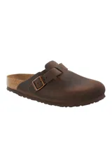 Zueco cerrado tipo clog, color marrón oscuro, con tira ajustable y hebilla metálica. Presenta una plantilla anatómica de corcho y ante, y suela de EVA.