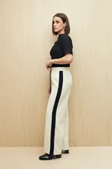 Pantalón de corte recto color negro con franjas laterales blancas a contratono. Cuenta con cintura elástica, cordones de ajuste y bolsillos laterales.