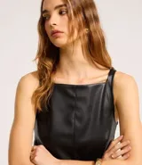 Vestido corto evasé negro de poliuretano con breteles finos y cinturón con hebilla metálica.