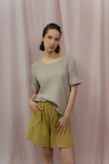 Short blanco de calce relajado con cintura elástica y lazo regulable. Presenta bolsillos amplios con ribete interior de color naranja neón.