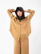 Camisa color ladrillo de corte amplio y mangas largas, con cuello camisero y cierre frontal con botones.