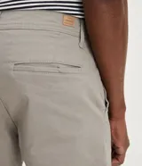 Pantalón de vestir color verde oscuro, corte slim, confeccionado en sarga de algodón y elastano.