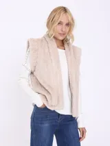 Chaleco de piel sintética color crema con diseño trenzado y bolsillos laterales.