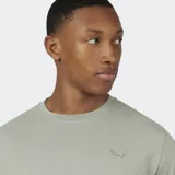 Remera de manga corta color verde claro, con cuello redondo y un pequeño logo bordado en el pecho.