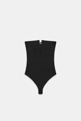 Body de tejido elástico color negro, con diseño strapless, escote recto con abertura frontal y cierre inferior con botones a presión.