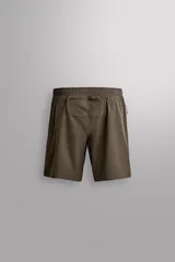 Shorts deportivos de entrenamiento Zara Athleticz, color beige, confeccionados en tejido técnico ligero y elástico con forro interior. Presentan cintura elástica ajustable, bolsillos frontales, bolsillo trasero de seguridad con cierre, aberturas laterales en el bajo y detalle de logo estampado en la pierna.