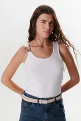 Musculosa blanca de algodón, corte ajustado, con escote redondo y tirantes finos adornados con argollas metálicas plateadas.