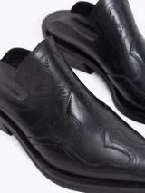 Zueco estilo western de cuero vacuno negro, con bordados decorativos en la capellada, punta cuadrada y taco bajo cuadrado.