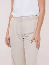 Pantalón de vestir de tiro alto, color beige, con corte wide leg y pinzas frontales.