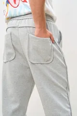 Pantalón de jogging gris con cintura elástica y cordón ajustable.