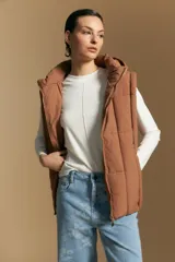 Chaleco acolchado de nylon color negro, con diseño capitoneado, capucha integrada y cierre frontal con tirador metálico.