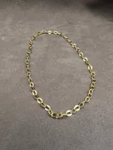 Collar tipo choker de cadena de eslabones ovalados con baño en oro de 18k, de diseño minimalista y atemporal.