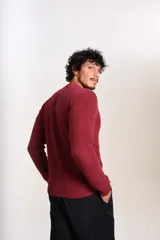 Sweater de punto grueso con cuello redondo y manga larga. Presenta un diseño de tejido acanalado y el logo de la marca bordado en el pecho.