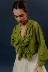 Camisa verde de manga larga, con volados frontales y detalles de puntilla bordada.
