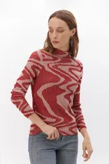 Polera de cuello alto y manga larga, confeccionada en tejido de punto con diseño geométrico de líneas onduladas en contraste de color rojo y beige.