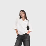 Chomba blanca de algodón de corte oversize, con cuello polo y bordado pequeño en el pecho.