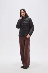 Campera puffer negra de nylon con diseño acolchado, cierre frontal y capucha integrada.