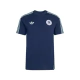 Remera de algodón azul marino con cuello redondo y mangas cortas. Presenta el logo de Adidas Trefoil bordado en blanco en el lado derecho del pecho y el escudo de la selección alemana de fútbol en el lado izquierdo. Incluye las icónicas tres tiras de la marca en color celeste claro a lo largo de los hombros y mangas.