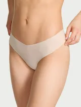 Panty tipo colaless de microfibra color beige, de tiro bajo y diseño sin costuras con acabado invisible bajo la ropa.