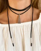 Gargantilla choker de tiras finas de gamuza negra con dije triangular plateado y terminales cilíndricos plateados.