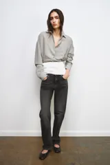 Jeans de tiro medio y corte recto, confeccionados en algodón con efecto lavado en tono gris oscuro. Presentan cintura con trabillas, cierre frontal con cremallera y botón, y diseño clásico de cinco bolsillos.