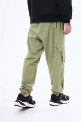 Pantalon cargo negro de corte holgado, con bolsillos laterales con solapa y puños elásticos en los tobillos. Cuenta con cintura elástica con cordón de ajuste.