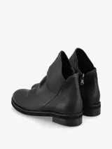 Botín negro de cuero italiano con diseño asimétrico y líneas modernas.