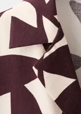 Camisa de manga corta con estampado de plumas y cuello camisero, con cierre frontal de botones.