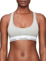 Bralette deportivo Calvin Klein Modern Cotton, color gris, sin relleno ni forro, con espalda cruzada y banda inferior elástica blanca con logo de la marca.
