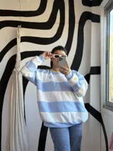 Buzo deportivo celeste y blanco a rayas horizontales, con cuello redondo amarillo y puños y ruedo en celeste.