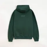 Hoodie de color verde oscuro confeccionado en friza, con capucha, cordones ajustables y bolsillo canguro. Presenta una estampa frontal blanca con el texto 'AnmeEdition' y 'CLUB' en un diseño ovalado de estilo desgastado.