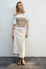 Top de escote asimétrico y manga corta, color blanco con fajín superpuesto a contraste en tono beige y detalles de frunces laterales.