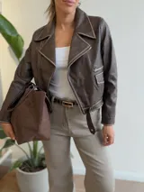 Campera tipo biker de ecocuero color chocolate con detalles de costuras en contraste color beige claro. Presenta cierre frontal metálico, bolsillos laterales con cierre y puños con cierre y botón a presión.