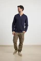 Remera de manga larga en tejido elastizado, color azul, con cuello tipo camisa, cartera con botones y detalles en eco gamuza en la base del cuello y la cartera.