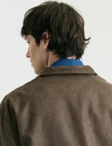 Campera de napa ecológica color marrón, con cierre frontal metálico, bolsillos laterales y cuello camisero.
