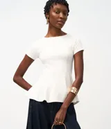 Blusa peplum color marfil, confeccionada en punto Roma, con mangas cortas, escote redondo y costuras estructuradas que realzan la silueta.