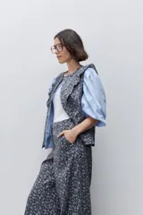 Pantalón de tiro alto con silueta amplia y piernas rectas, confeccionado en algodón con estampado floral. Cuenta con cierre frontal de botón y cremallera, y bolsillos laterales funcionales.