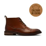 Bota de vestir tipo chukka de cuero color marrón, con cordones, puntera reforzada y suela de madera con taco bajo.