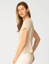 Remera blanca de manga corta con cuello redondo, confeccionada en una mezcla de modal, poliéster y elastano. Presenta un diseño con alforzas verticales en el frente que aportan estructura y una silueta relajada.