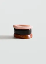 Set de tres pulseras rígidas de resina en tonos rosado, marrón oscuro y carey.