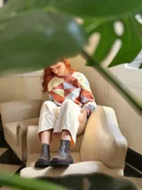 Sweater de punto con diseño geométrico en tonos celeste, marrón y beige.