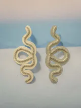 Aros colgantes con forma de serpiente blanca delineada con strass plateado.