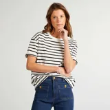 Remera oversize de algodón color blanco con rayas horizontales negras, cuello redondo y mangas cortas.