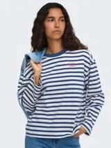 Remera de manga larga a rayas horizontales en tonos marrón y tostado, con cuello redondo y el texto "vibrant studio" estampado en el pecho.