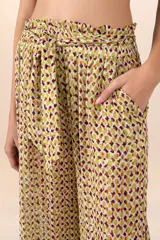 Pantalón de corte recto con pretina elástica y lazo para ajustar. Diseño con estampado abstracto en tonos amarillo, verde y violeta.